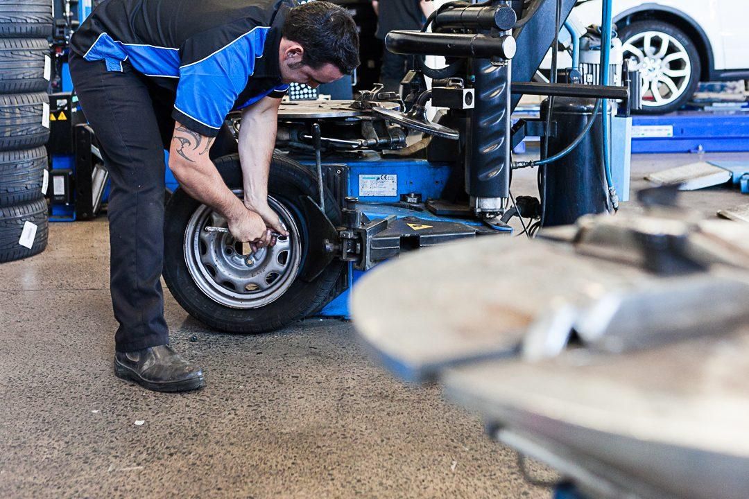 A Tyre Tracks technician fitting a tyre in the Te Rapa workshop